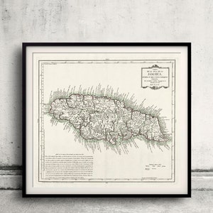 Op de afbeelding: Een antieke kaart van Jamaica, gedrukt in zwart-wit met groene en rode accenten. De kaart toont de kustlijn van het eiland, rivieren en steden. De titel "Carte de L'Isle de la JAMAICA" staat bovenaan de kaart gedrukt.