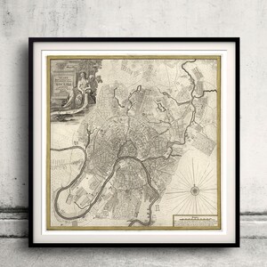 Puede incluir: Un mapa antiguo de Moscú, Rusia, impreso en blanco y negro sobre papel color crema. El mapa muestra el diseño de la ciudad con calles, edificios y vías fluviales. El título "Plan de la Ville de Moscou" está impreso en la esquina superior izquierda.