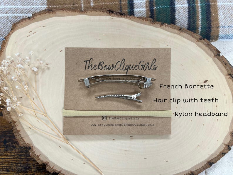 May include: A set of hair accessories, including a French barrette, a hair clip with teeth, and a nylon headband, displayed on a wooden surface. The brand name "The Bow Clique Girls" is printed on a brown card.