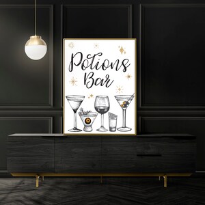May include: A framed print with the words "Potions Bar" in elegant script, featuring detailed illustrations of various cocktail glasses. The artwork includes a martini, a wine glass, and other drinkware, with gold star accents.