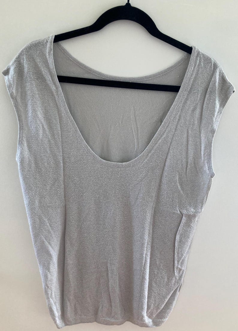 May include: A light gray sleeveless top with a scoop neck.