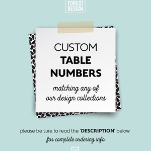 May include: White card with black text that reads "CUSTOM TABLE NUMBERS matching any of our design collections". The card is taped to a black and white patterned background. The text "please be sure to read the 'DESCRIPTION' below for complete ordering info" is below the card.