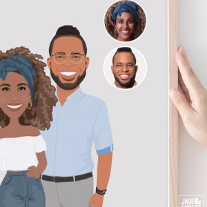 May include: A framed illustration featuring a couple and two circular portraits. The couple is depicted in a cartoon style, with the woman wearing a white off-the-shoulder top and jeans, and the man in a light blue shirt and gray pants. The portraits show the couple's faces. The frame is light wood.