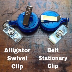 May include: Two blue retractable badge reels with different clip styles: an alligator swivel clip and a belt stationary clip. Each reel has a clear, decorative tag attached. The text on the image reads "Alligator Swivel Clip" and "Belt Stationary Clip."