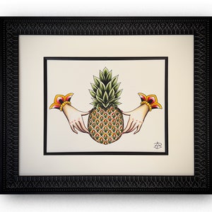 May include: A framed illustration of a pineapple with two hands holding it. The pineapple is green and yellow with a brown base. The hands are white with red and yellow accents. The frame is black with a decorative border.