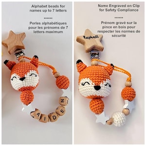 May include: A pacifier clip featuring a crocheted orange and white fox head, wooden star-shaped clip, and a string of beads. The beads include round orange crochet spheres, white wooden stars, and wooden cubes with letters spelling names.