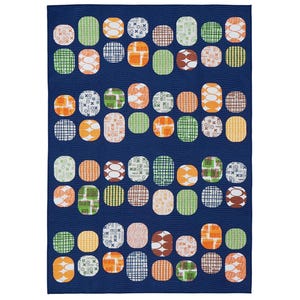 May include: A blue fabric with a repeating pattern of colourful circles. The circles have different geometric patterns in shades of green, orange, and white.