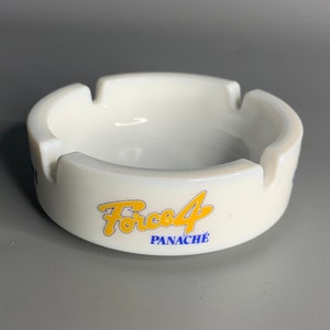 May include: White ceramic ashtray with a yellow and blue logo that says "Force 4 Panache".