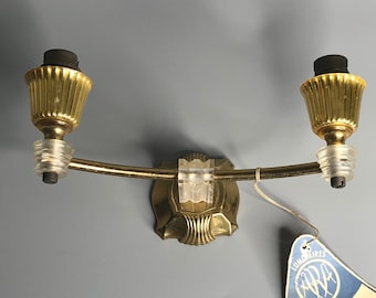 Könnte beinhalten: Eine goldfarbene Wandleuchte mit zwei Leuchten. Die Leuchte hat ein dekoratives Design und ist an einer Wand befestigt. Ein blaues und weißes Etikett mit dem Text "REF. A.P. 17/2  PRIX:  " ist an der Leuchte befestigt.