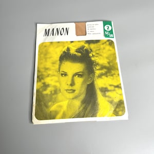 May include: A vintage package of MANON brand pantyhose. The packaging features a yellow-toned image of a woman with text that reads "MANON" in bold, black letters. Additional text and numbers are visible on the packaging.