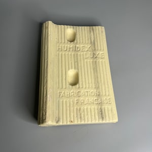 May include: A white ceramic humidifier brick with the text "HUMIDEX LUXE" and "FABRICATION FRANCAISE".