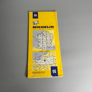 Puede incluir: Un mapa de carreteras Michelin vintage, con una cubierta amarilla y el número "55" en azul. El mapa incluye una ilustración detallada de una región, con texto en francés. El logotipo de Michelin es visible en la parte superior.