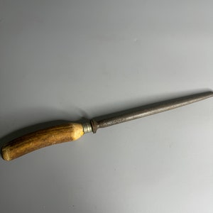 May include: A vintage steel knife sharpener with a brown antler handle. The sharpener is marked "TUSK & CO."