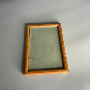 May include: A simple wooden picture frame with a light green mat. The frame is rectangular and has a slightly distressed finish.