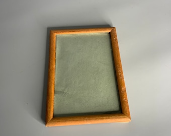 May include: A simple wooden picture frame with a light green mat. The frame is rectangular and has a slightly distressed finish.
