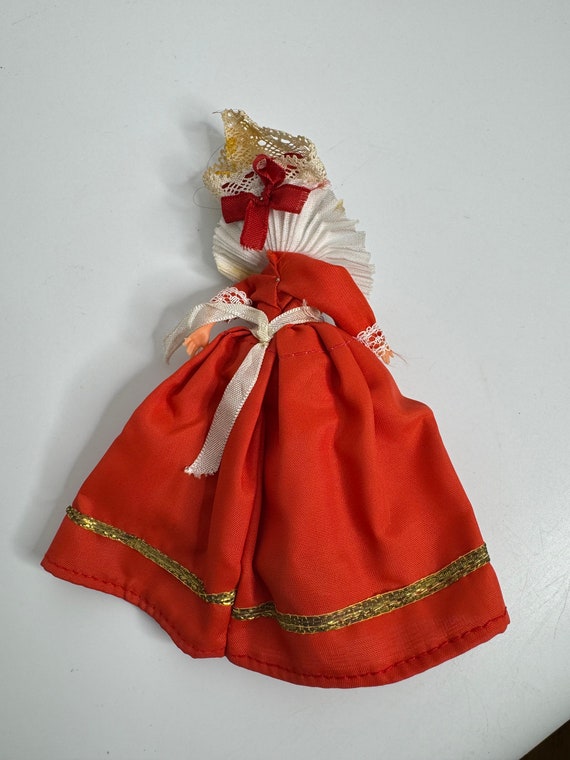 レースの赤いドレスを着たフランスのヴィンテージの眠っている人形