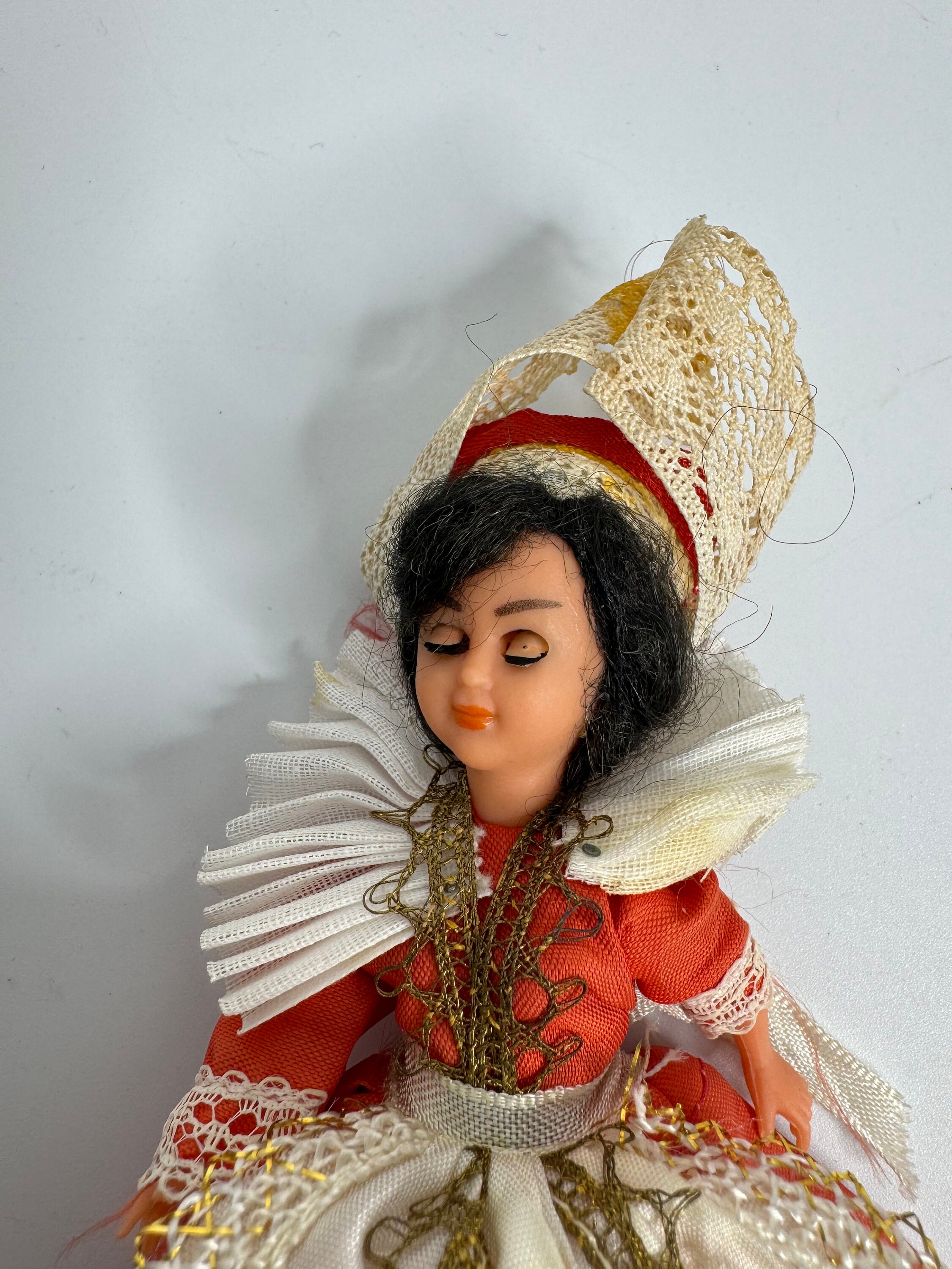 レースの赤いドレスを着たフランスのヴィンテージの眠っている人形