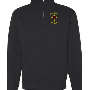 May include: Black sweatshirt with a quarter-zip collar. The sweatshirt features a design on the upper left chest with the text "TEXT LINE 1" and "TEXT LINE 2" surrounding a red and yellow emblem.