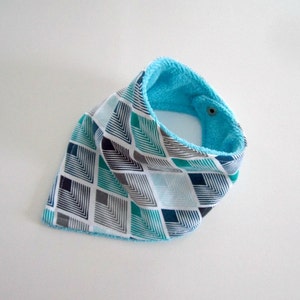 Puede incluir: Un babero bandana estampado en turquesa y blanco con un forro de felpa turquesa suave.
