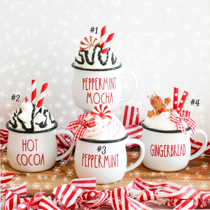 May include: Four white ceramic mugs with red and black lettering and different holiday-themed toppings. The mugs are labeled #1 Peppermint Mocha, #2 Hot Cocoa, #3 Peppermint, and #4 Gingerbread.