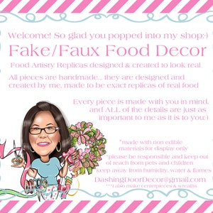May include: A cartoon image on a pink and white striped background, with the text "Fake/Faux Food Decor." The image shows a woman with glasses holding craft tools. The text describes handmade food replicas designed to look real.
