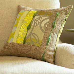 Cojín cuadrado decorativo con acento. Cojín único. Patchwork moderno con textura. Telas de diseño en tonos lima, verde salvia y beige. Lino, arpillera y lana.