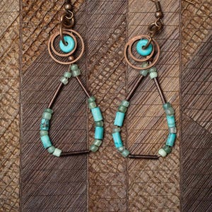 Copper boho-style dangle earrings made from turquoise stone heishi beads, antique-copper tubes, Czech glass beads, and copper hoops.