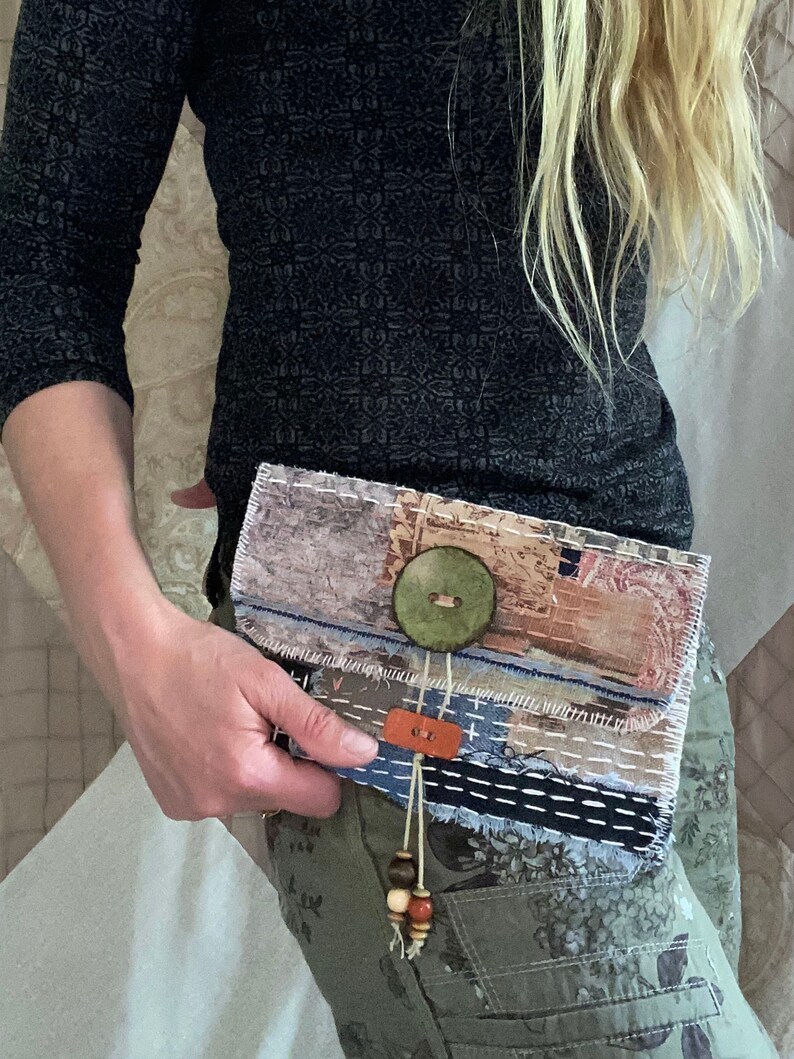 May include: A small, multi-colored fabric clutch with a large green button and a brown leather strap with wooden beads. The clutch is made of various fabrics and has a patchwork design.