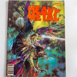 May include: Vintage "Heavy Metal" magazine cover from August 1978. The cover art features a fantastical scene with a winged creature, a woman, and the magazine's title in bold orange letters. The background is a mix of blues, greens, and purples.