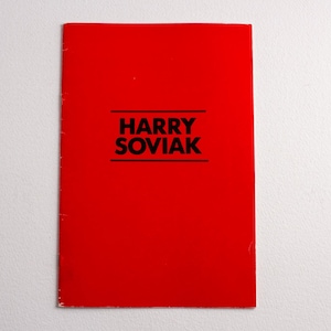 May include: A rectangular booklet with a vibrant red cover. Centered on the front is the text HARRY SOVIAK printed in bold black capital letters, positioned between two horizontal black lines. The booklet has a stapled spine on the left side.