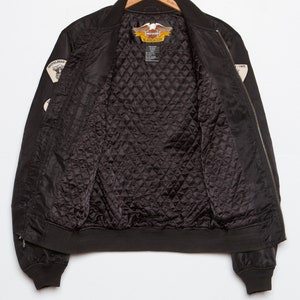 May include: Black bomber jacket with a quilted lining and Harley Davidson patches on the sleeves. The patches feature the Harley Davidson logo and the words "An American Legend".