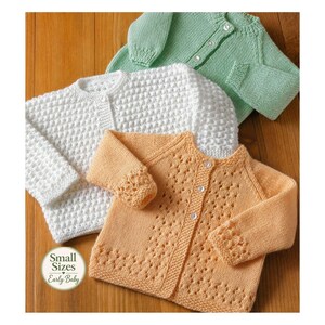 Può includere: Tre cardigan a maniche lunghe per neonati in verde chiaro, bianco e pesca. Il cardigan verde è a maglia liscia, quello bianco ha un motivo testurizzato e quello pesca un design traforato. Ognuno ha una chiusura a bottoni. Il testo recita Small Sizes Early Baby.