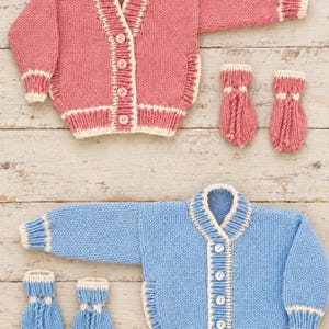 Puede incluir: Dos conjuntos de cárdigans tejidos a mano, uno en rosa empolvado y otro en azul claro. Cada conjunto incluye un cárdigan de manga larga con botones y ribetes color crema en puños, dobladillo y cuello, junto con un par de manoplas a juego.