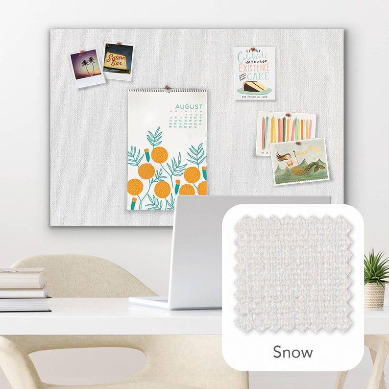 Pu&ograve; includere: Una bacheca in tessuto bianco con vari elementi decorativi appuntati, tra cui un calendario di agosto con illustrazioni di arance e diverse piccole immagini. Un campione di tessuto &egrave; etichettato "Snow".