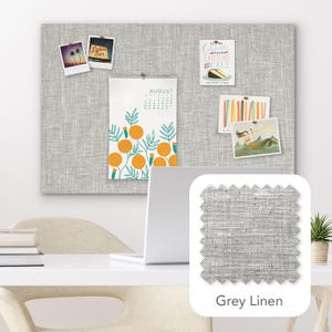 Pu&ograve; includere: Una bacheca in lino grigio con vari elementi appuntati, tra cui un calendario di agosto, foto polaroid e altre carte decorative. Viene mostrato un campione del tessuto di lino grigio. Un laptop &egrave; su una scrivania bianca.