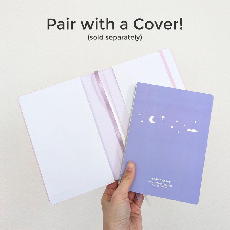 May include: A lavender weekly planner with a crescent moon and star design, held next to a pink notebook cover. The text "Pair with a Cover!" is displayed above the notebooks.