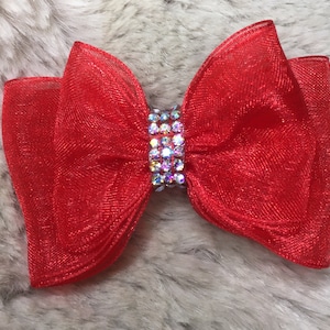 May include: A large red mesh bow with a row of clear rhinestones in the center.