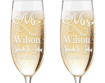 May include: Two champagne flutes with the words "Mr. Wilson Sarah & John 06.20.20" and "Mrs. Wilson Sarah & John 06.20.20" etched on them.