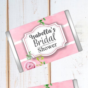 May include: Four pink and white striped favor boxes with silver trim. Each box has a floral design and the text "Isabella's Bridal Shower".