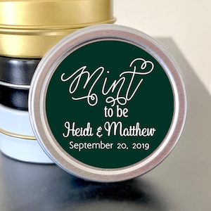 May include: Stack of small round silver tins with a green label that says "Mint to be Heidi & Matthew September 20, 2019".
