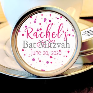 May include: A round, silver tin with a white label featuring pink confetti and the text "Rachel's Bat Mitzvah June 20, 2020".