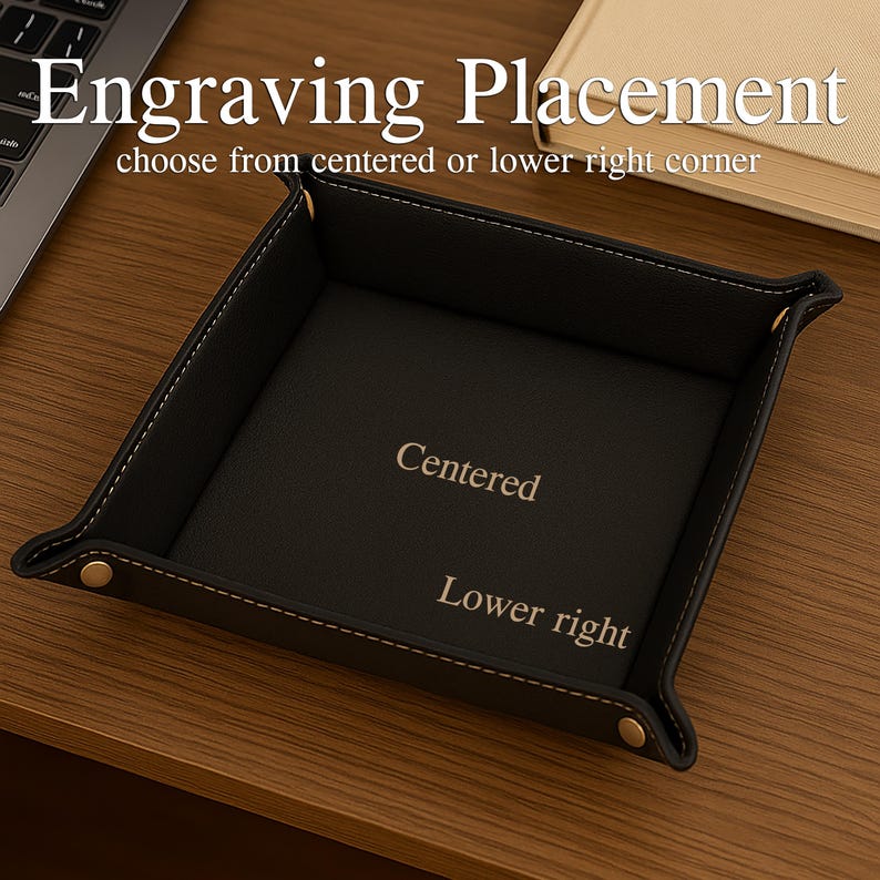 Pode incluir: Uma bandeja de couro preta com costuras brancas e rebites dourados. A bandeja tem o texto "Engraving Placement" e "choose from centered or lower right corner". As palavras "Centered" e "Lower right" tamb&eacute;m s&atilde;o vis&iacute;veis.