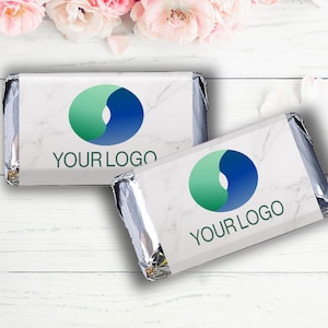 May include: Two silver foil-wrapped chocolate bars with a white marble design. Each bar features a blue and green logo with the text "YOUR LOGO".