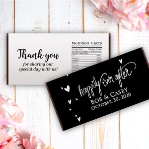 May include: Black chocolate bar with white text that reads "happily ever after" with the names Bob & Casey and the date October 30, 2020. The bar is surrounded by small white hearts.