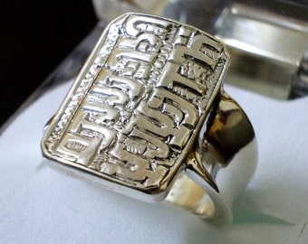 May include: A silver ring with a raised inscription that reads "D.A.D." The inscription is in a bold, blocky font.