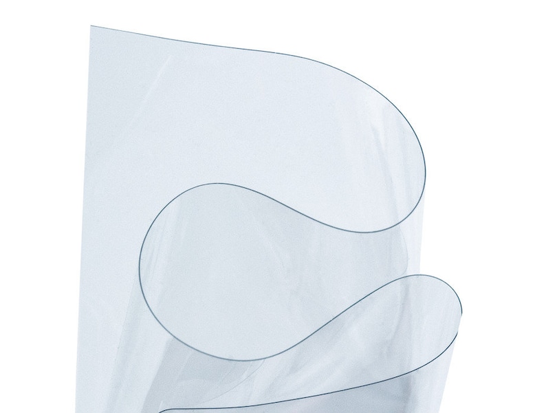 May include: Clear plastic sheet, rolled up, showing the transparency of the material.