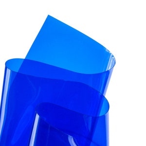 Puede incluir: Primer plano de una lámina de plástico transparente azul doblada sobre sí misma. La lámina es translúcida y tiene un ligero brillo.