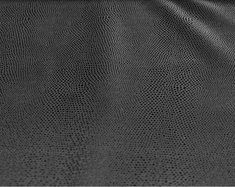 May include: Close-up of a dark gray textured fabric with a subtle pattern of small, raised dots.