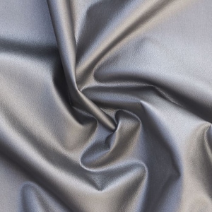 Può includere: Primo piano di un tessuto in similpelle argentato con una texture grinzosa.