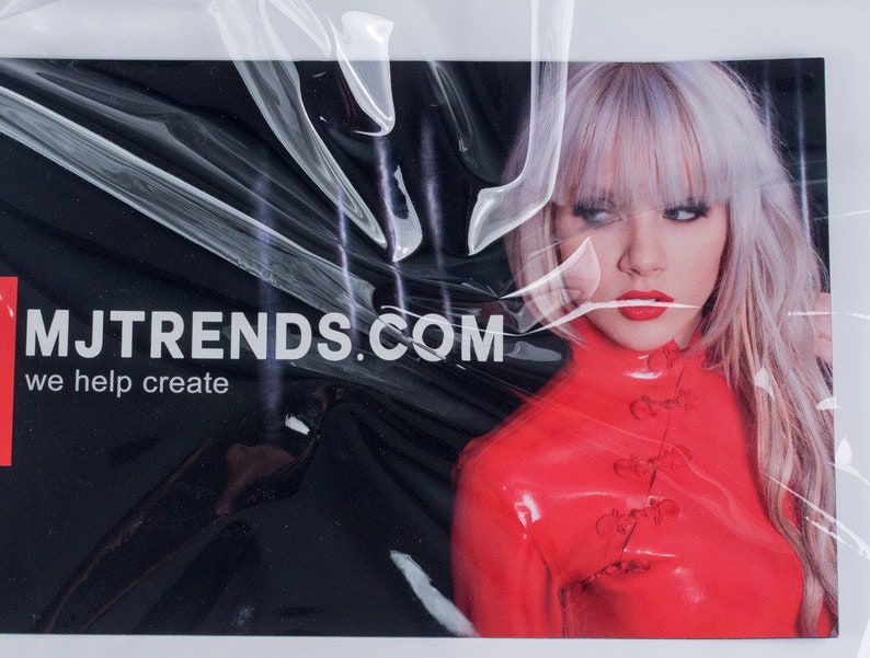 May include: A black and red business card with the text "MJTRENDS.COM" and the phrase "we help create". A woman with blonde hair and red lipstick is in the background wearing a red latex outfit.